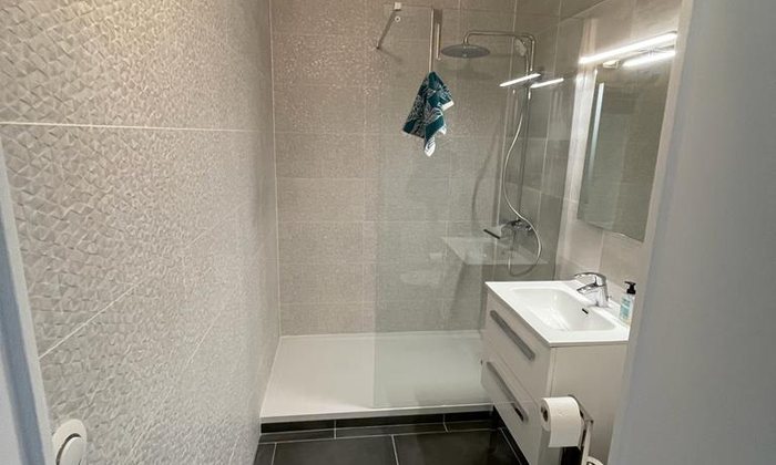 Douche à l’italienne et vasque dans une salle de bain rénovée